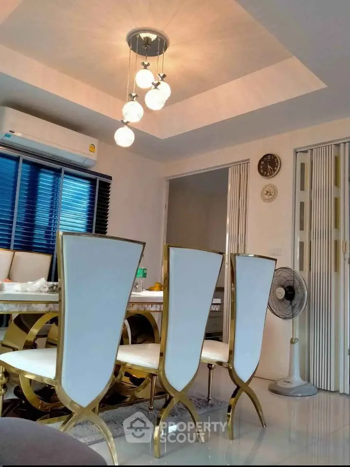 Elegant dining room with modern chandelier and stylish chairs in a contemporary home.