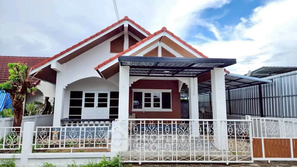 Charming single-story house with a red-tiled roof and spacious front yard