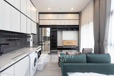 Modern living room with sleek furniture and built-in storage, featuring a washing machine and smart TV.