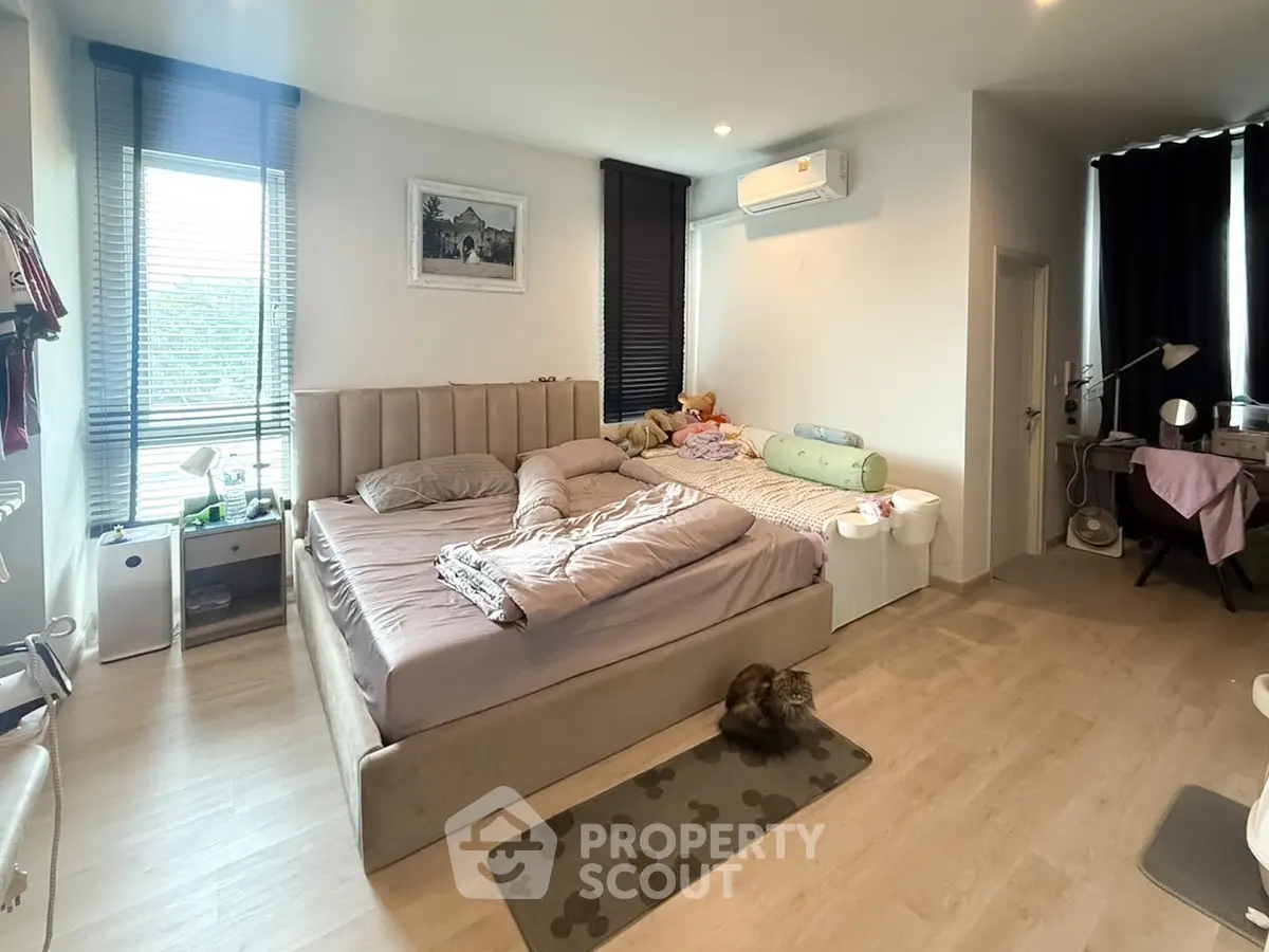 Spacious bedroom with modern decor and large windows for natural light
