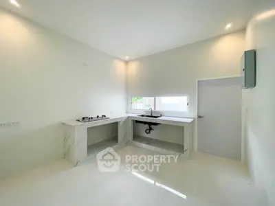 Modern minimalist kitchen with sleek white countertops and built-in gas stove