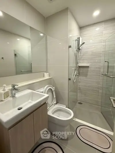 Modern bathroom with glass shower and sleek fixtures in a contemporary apartment.