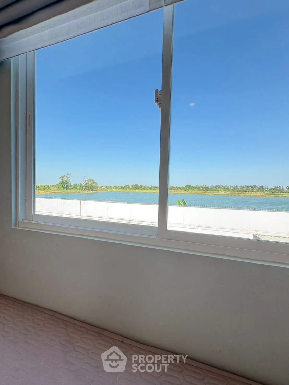 Stunning river view from a modern apartment window, offering serene and picturesque scenery.