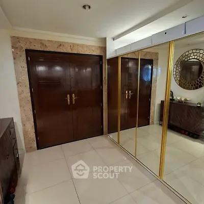 Elegant entryway with mirrored closet doors and polished wooden accents