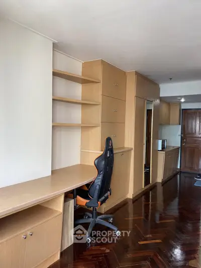 Spacious study area with built-in shelves and ergonomic chair in modern apartment