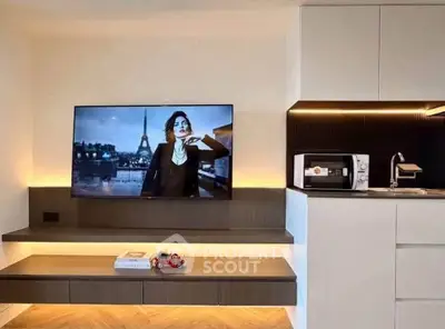 Modern living room with sleek TV setup and stylish kitchen area
