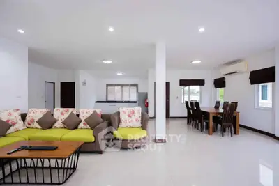 Spacious open-plan living and dining area with modern furnishings and ample natural light.