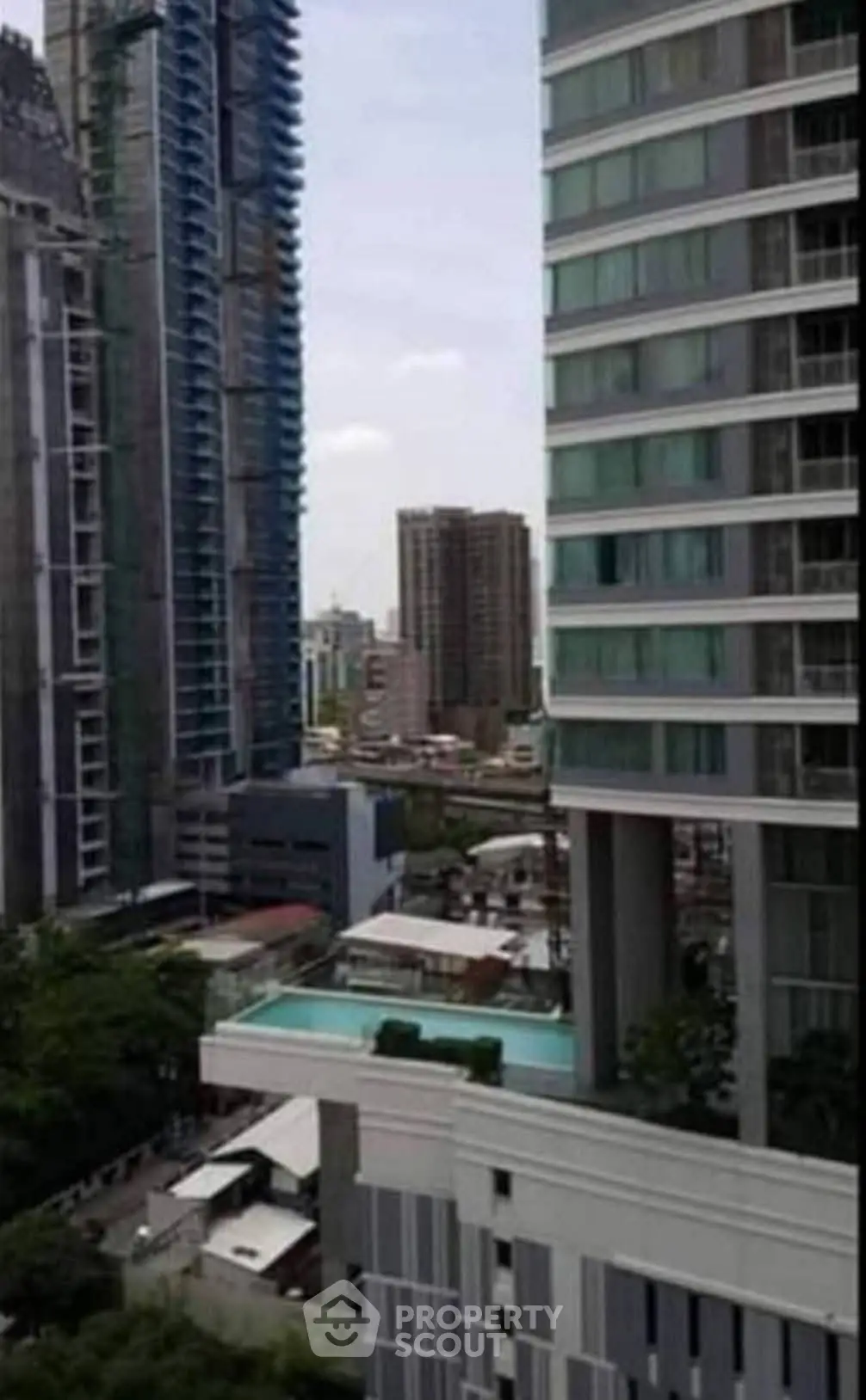 Stunning urban high-rise view with modern architecture and rooftop pool.