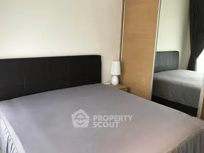 Spacious bedroom with modern design and mirrored wardrobe in a stylish apartment.