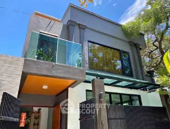 Modern two-story house with glass balcony and sleek design