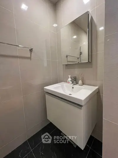 Modern bathroom with sleek vanity and mirror in a stylish setting.