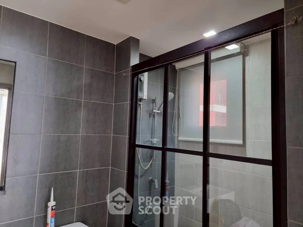 Modern bathroom with sleek glass shower and gray tile design