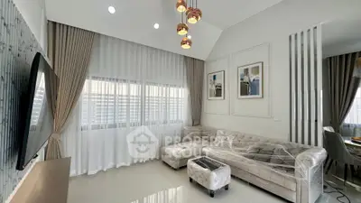 Modern living room with elegant decor and large windows, featuring a stylish sofa and contemporary lighting.