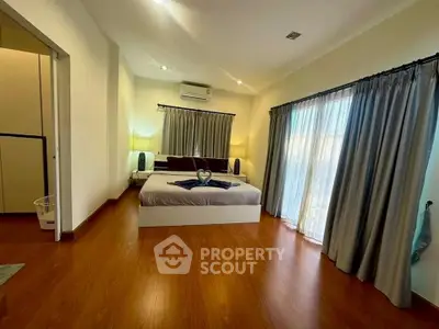 Spacious bedroom with elegant decor and large windows for natural light.