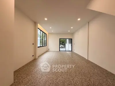 Spacious modern living room with large windows and terrazzo flooring