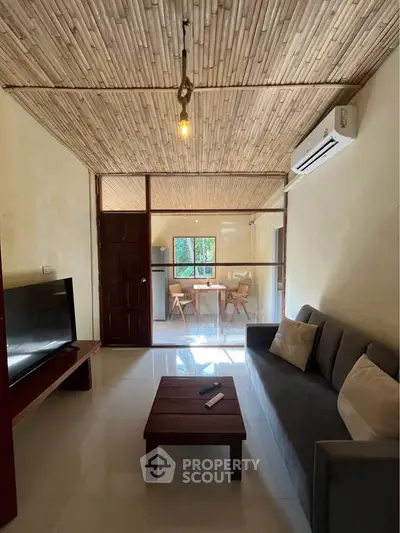 Charming living room with bamboo ceiling and modern furniture, perfect for cozy gatherings.
