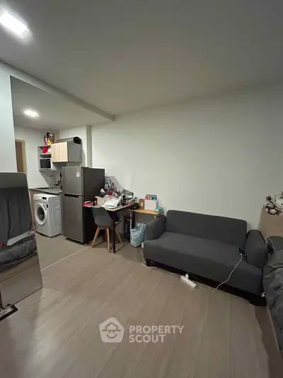 Cozy apartment interior with modern kitchen and living area, featuring compact appliances and stylish furniture.