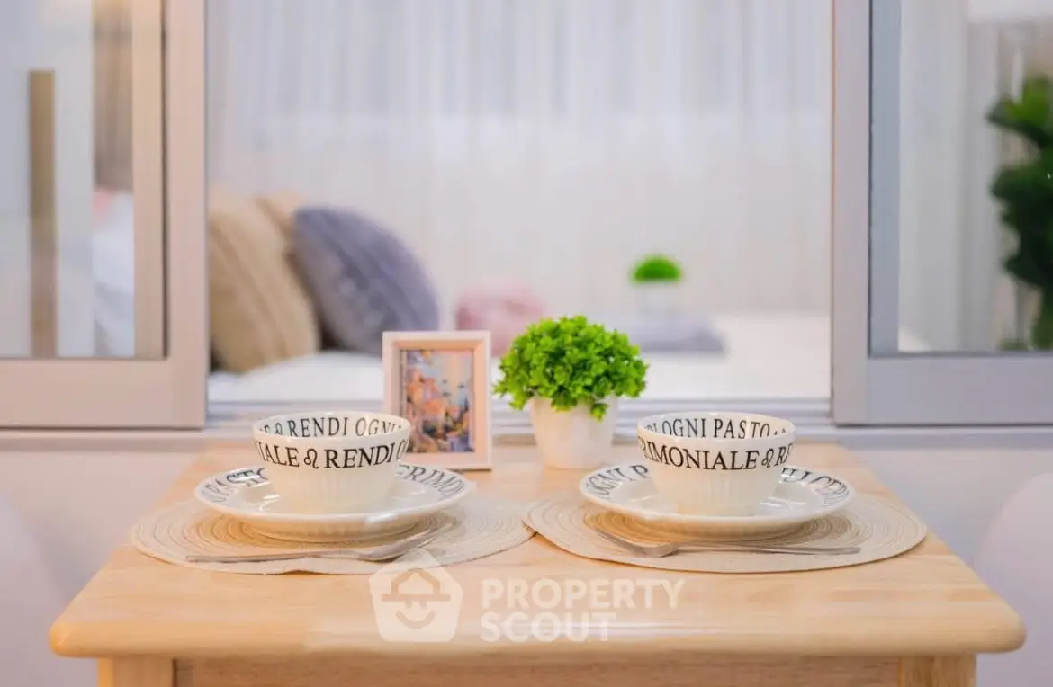 Cozy dining setup with elegant tableware and a glimpse of a stylish bedroom.