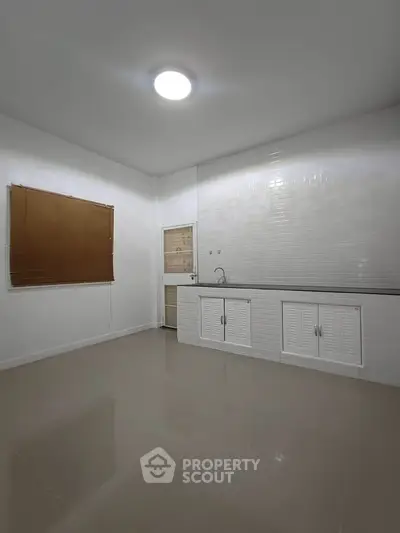 Minimalist kitchen with sleek white cabinets and modern lighting