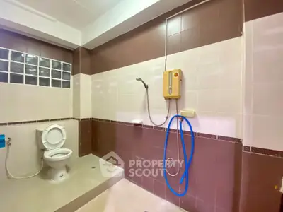 Spacious bathroom with modern shower and toilet in a stylish real estate property.