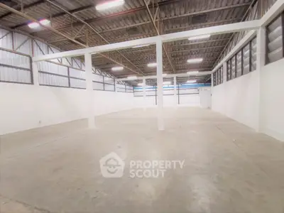Spacious industrial warehouse with high ceilings and ample natural light.