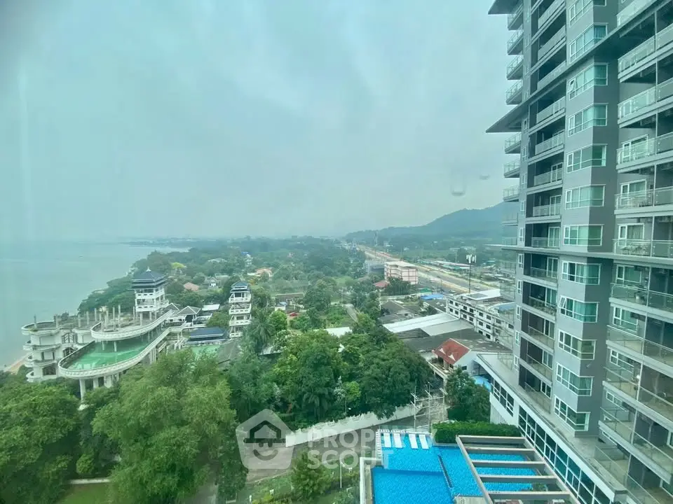Stunning high-rise building with panoramic sea and city views, featuring lush greenery and modern architecture.
