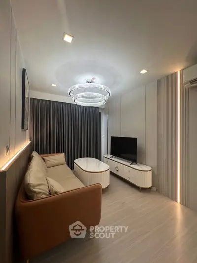Modern living room with sleek design, featuring a cozy sofa, stylish lighting, and a flat-screen TV.