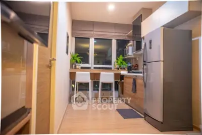Modern kitchen with sleek appliances and cozy dining area, perfect for urban living.
