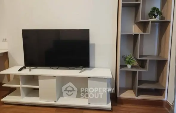 Modern living room with sleek TV stand and stylish shelving unit.
