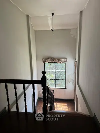 Charming staircase with natural light and vintage wooden railing