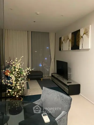 Modern living room with stylish decor, large window, and elegant furniture in a high-rise apartment.