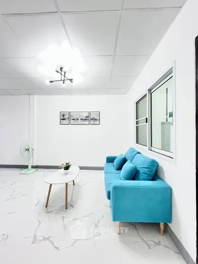 Modern living room with turquoise sofa and minimalist decor