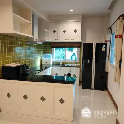 Modern kitchen with sleek black refrigerator and stylish tile backsplash