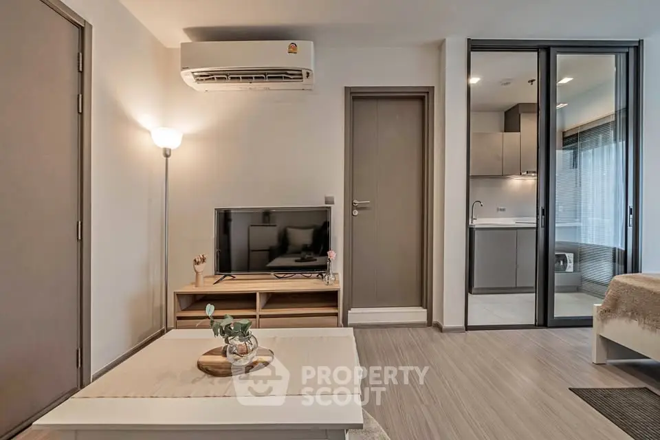 Modern living room with sleek design and open kitchen layout, featuring stylish furniture and ambient lighting.