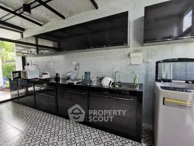 Modern kitchen with sleek black cabinetry and stylish tile flooring