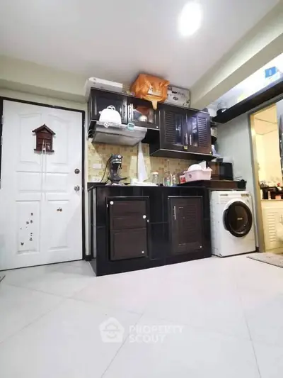 Modern kitchen with sleek black cabinets and washing machine