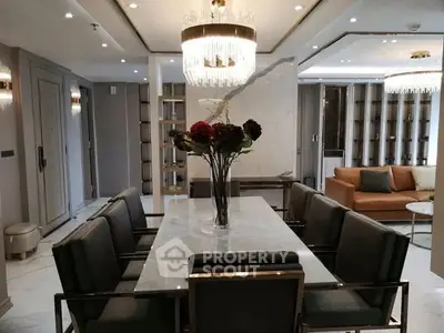Luxurious dining area with elegant chandelier and marble table in modern apartment.