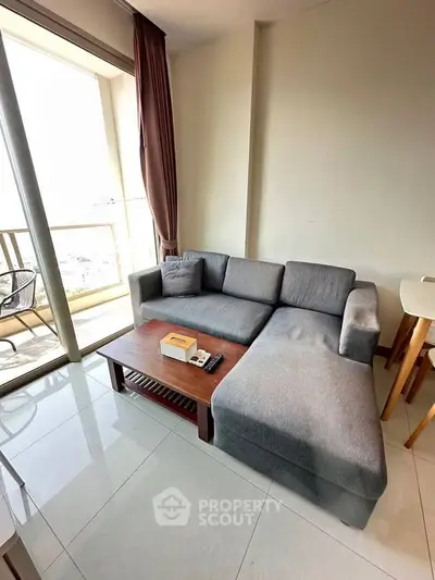 Modern living room with cozy gray sectional sofa and balcony view