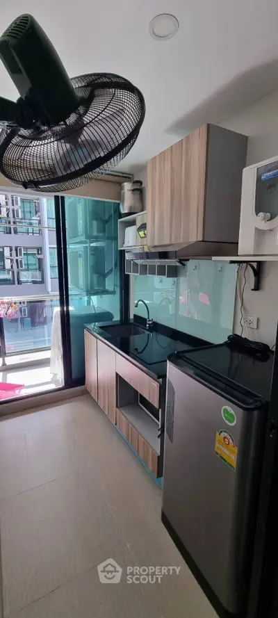 Modern kitchen with sleek appliances and balcony view in urban apartment