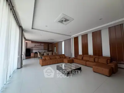 Spacious modern living room with large sectional sofa and open kitchen layout