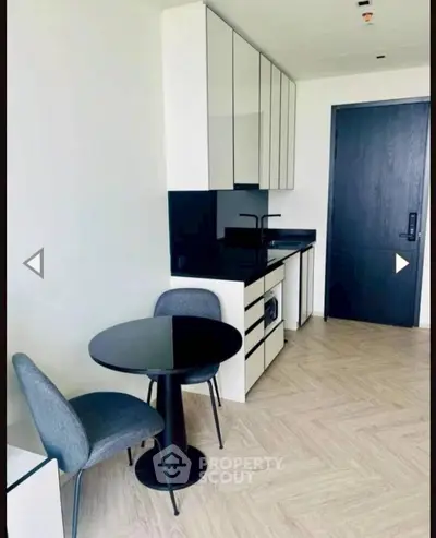 Modern kitchen with sleek cabinetry and dining area in stylish apartment
