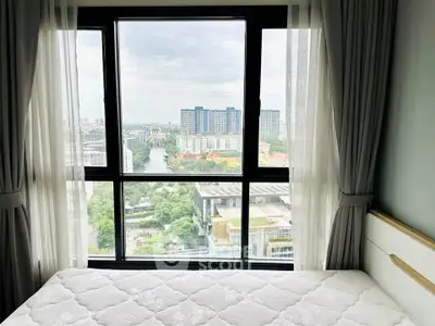 Bright bedroom with large window offering stunning city view in modern apartment.