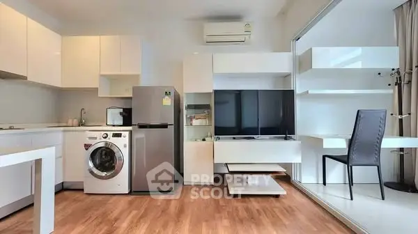 Modern open-layout kitchen with washing machine and sleek appliances in a stylish apartment.