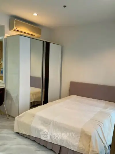 Modern bedroom with sleek wardrobe and cozy bed in a stylish apartment.