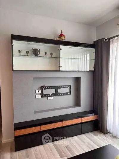 Modern living room with sleek black entertainment unit and glass display cabinet