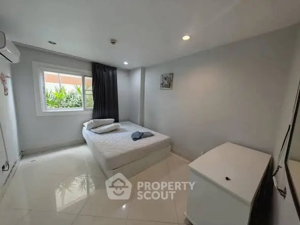 Modern minimalist bedroom with natural light and sleek tile flooring.