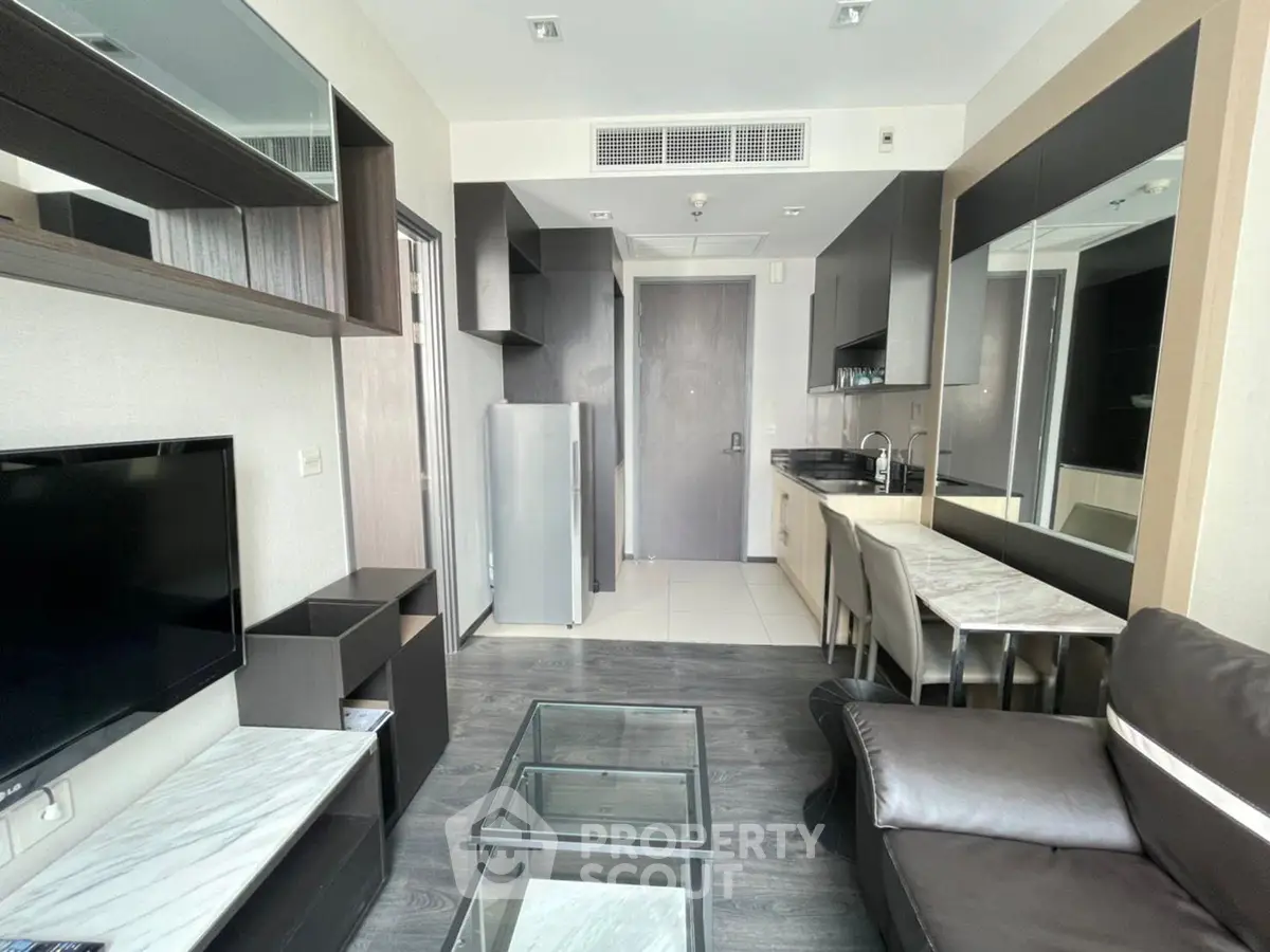 Modern living room with sleek furniture and open kitchen layout in a stylish apartment.