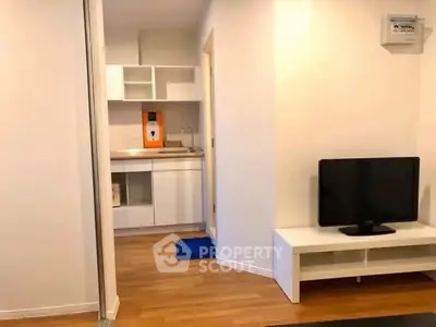 Modern compact living room with kitchenette and TV setup