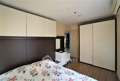 Cozy bedroom with floral bedding and ample storage in modern apartment.
