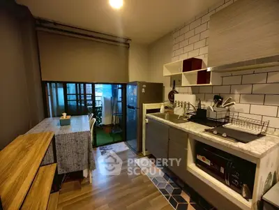 Modern kitchen with dining area and balcony access in stylish apartment.